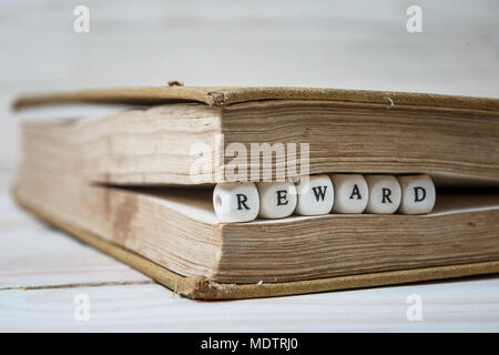 Premio Parola scritta in blocchi di legno nel libro bianco sul tavolo di legno Foto Stock