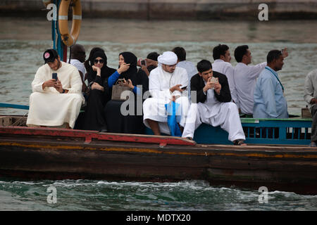 La popolazione locale che attraversa il Torrente di Dubai su un abra, Dubai, Emirati Arabi Uniti, Medio Oriente Foto Stock