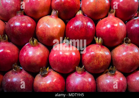 Gruppo di melograni. Melograno closeup, sfondo. frutti maturi ordinatamente stabilito sul bancone del negozio Foto Stock