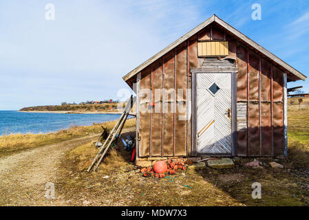La pesca tradizionale capannone con il paesaggio costiero in background. Ubicazione Aleklinta su Oland, Svezia. Foto Stock
