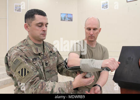 Aviosuperficie di Bagram, Afghanistan - il sergente di prima classe Bartolomeo Anderson, Senior medic per la terza divisione di fanteria sostegno deciso supporto brigata, dimostra l'applicazione di un fissatore sul Lt. Col. Charles Noble, la terza Inf. Div. RSSB chirurgo, durante un corso di primo soccorso sul campo di aviazione Bagram, Afghanistan, DIC 6. Il corso era intesa a introdurre afgano professionisti legali di primo soccorso nozioni di base nel caso in cui essi sono attaccati durante lo svolgimento delle loro funzioni al fine di garantire un regolare ed equo sistema di giustizia nel paese. (U.S. Esercito foto di Sgt. 1. Classe Ben K. Navratil, 3° ID RSSB - rilasciato Foto Stock