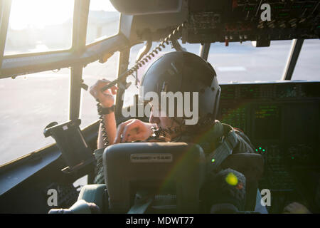 Il cap. La Giordania Hechinger, XLI Troop Carrier Squadron C-130J Super Hercules pilota, cinghie se stesso nel sedile del pilota durante l'esercizio vigili Ace 18, 6 dicembre 2017, a Yokota Air Base, Giappone. L'esercizio testato Yokota la prontezza e la capacità di ricevere e distribuire le forniture o le forze in Indo-Asia regione del Pacifico. (U.S. Air Force foto di Senior Airman Donald Hudson) Foto Stock