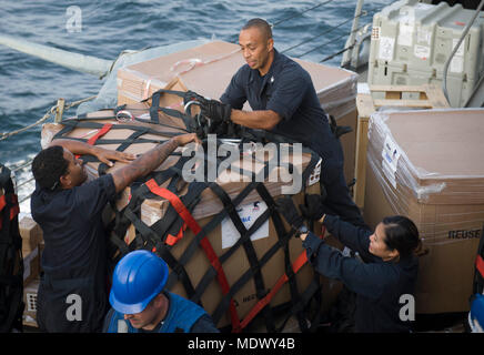 171209-N-IA905-1166 GOLFO ARABICO (dec. n. 9, 2017) specialista culinaria di prima classe Fernando Rodriguez, centro, rimuove il carico al netto da una spedizione di posta durante un rifornimento in mare a bordo del Arleigh Burke-class guidato-missile destroyer USS Preble (DDG 88). Preble viene implementato con Theodore Roosevelt Carrier Strike gruppo per gli Stati Uniti Quinta Flotta area di operazioni a sostegno della sicurezza marittima operazioni per rassicurare gli alleati e partner e preservare la libertà di navigazione e il libero flusso di commercio nella regione. (U.S. Foto di Marina di Massa lo specialista di comunicazione di terza classe Morgan K. Nal Foto Stock