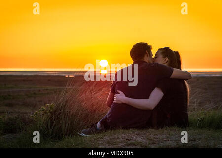 Tramonto mozzafiato, Southport, Merseyside. Xx Aprile 2018. Regno Unito Meteo. Una giovane coppia romantica sneak Un affettuoso bacio come un tramonto spettacolare si accoccola nell'orizzonte dopo una bella giornata di primavera in Southport, Merseyside. Credito: Cernan Elias/Alamy Live News Foto Stock