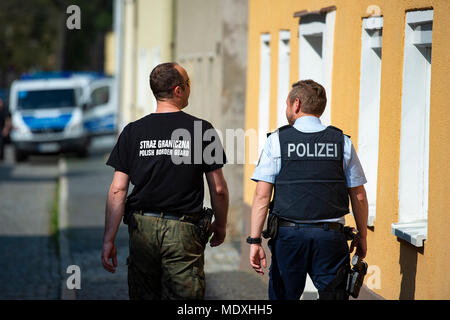 Ostritz, Germania. Xxi Aprile, 2018. In Germania un funzionario di polizia (r) e una frontiera polacca ufficiale di pattuglia a piedi intorno alla città di Ostritz durante il suo "Festa della pace", un evento organizzato per contrastare un neo-nazi festival in Ostritz. Foto: Nils Holgerson/dpa Credito: dpa picture alliance/Alamy Live News Foto Stock