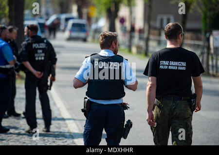Ostritz, Germania. Xxi Aprile, 2018. In Germania un funzionario di polizia e una frontiera polacca ufficiale di pattuglia (r) a piedi intorno alla città di Ostritz durante il suo "Festa della pace", un evento organizzato per contrastare un neo-nazi festival in Ostritz. Foto: Nils Holgerson/dpa Credito: dpa picture alliance/Alamy Live News Foto Stock