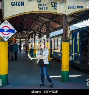 Una donna in piedi in corrispondenza di una stazione di Darjeeling Toy Train, la Darjeeling Himalayan Railway; Ghoom, West Bengal, India Foto Stock