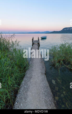 Il pescatore molo sul Lago di Garda Lago di Garda) all'alba nel Garda in Veneto, Italia Foto Stock