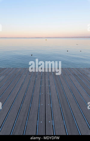 Il Boardwalk all'alba che si affaccia sul Lago di Garda Lago di Garda) a Bardolino in Veneto, Italia Foto Stock