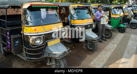 Auto rickshaws parcheggiato in una fila lungo una strada; Jaipur, Rajasthan, India Foto Stock