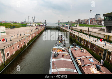 Rimorchiatore stoppa due barche di carico attraverso il piccolo blocco di IJmuiden Paesi Bassi Foto Stock