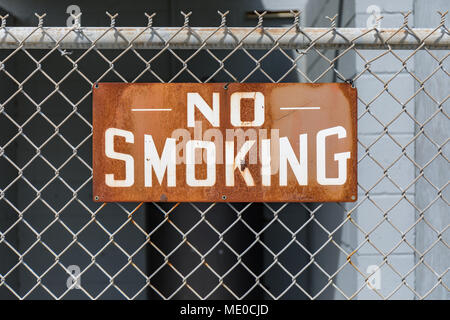Rusty vietato fumare in un recinto Foto Stock