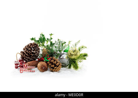 Decorazione di natale di coni fir,holly e bacche giacente sulla neve artificiale isolato su sfondo bianco Foto Stock