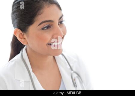 Medico donna sorridente e lo sguardo lontano, ritratto. Foto Stock