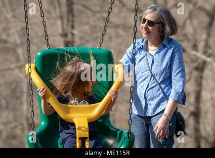 Nonna e nipote giocare in oscillazione in plastica Foto Stock