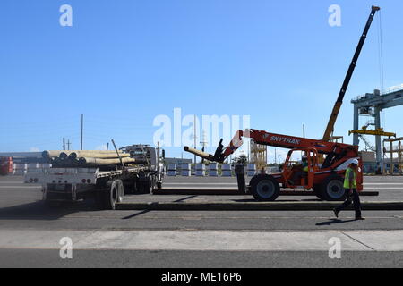 PONCE, PUERTO RICO (dec. n. 22, 2017) - pressione-in legno trattate poli di utilità sono scaricati presso la posa in cantiere Ponce, Puerto Rico, parte delle tonnellate di importanti componenti elettrici che fluisce nel quotidiano di tutta la nazione per ricostruire l'isola il sistema di distribuzione elettrica. Gli Stati Uniti Esercito di ingegneri' Task Force power restoration team, lavora 12 ore di turni e per sette giorni alla settimana, per completare la missione di ricostruzione di Puerto Rico hanno devastato la griglia di alimentazione. (U.S. Foto dell'esercito da Jerry Rogers) Foto Stock