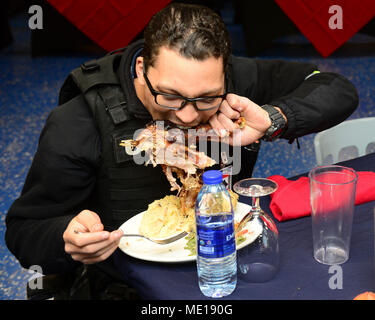 La base navale di KITSAP BREMERTON, nello Stato di Washington (Dec. n. 25, 2017) DEGLI STATI UNITI Navy Fire Controlman 3rd Class Jordan Morgan, da Glen carbonio, Ill., gode di una gamba della Turchia durante il pranzo di Natale a bordo Nimitz CVN (68), 25 dicembre 2017, presso la base navale di Kitsap Bremerton. Nimitz sta attualmente preparando un progetto di disponibilità incrementale a Puget Sound Naval Shipyard e Manutenzione intermedia struttura dove la nave riceveranno una manutenzione pianificata e aggiornamenti. (U.S. Foto di Marina di Massa lo specialista di comunicazione di terza classe Kennishah J. Maddux) Foto Stock