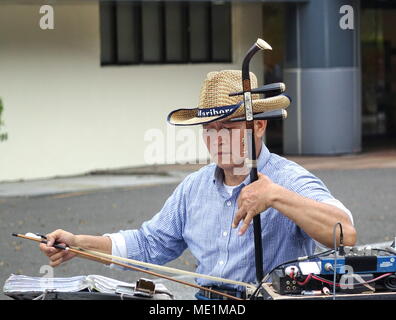 KAOHSIUNG, Taiwan -- Febbraio 16, 2018: un musicista di strada suona il erhu, a due corde di violino cinese, con un lungo arco. Foto Stock