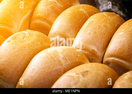 Close-up di fresca pane bianco in rotoli sorge anche in righe in una panetteria Foto Stock