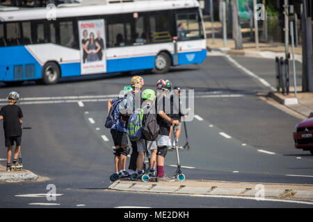 I ragazzi sullo skateboard in attesa di attraversare trafficata strada principale,Sydney , Australia Foto Stock