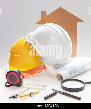 Progettazione tabella di lavoro strumento di scrittura ,attrezzature ,e casco di sicurezza contro i due punti di vista prospettica dell'edificio esterno Foto Stock