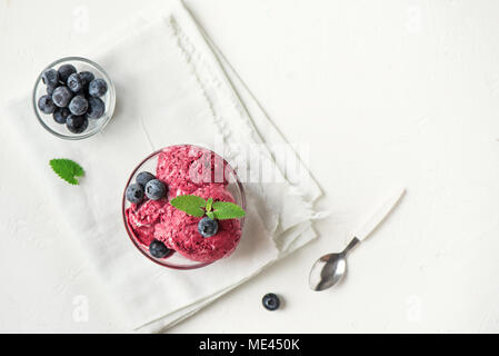In casa berry ice cream (gelato, nicecream) condito con mirtilli organico e menta - una sana dieta vegetariana vegan frutta cruda deliziosi organico de Foto Stock