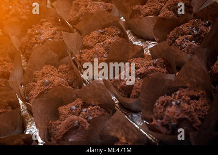 Close-up di fresco muffin al cioccolato, decorata con cioccolato e con cioccolata calda all'interno di righe pari Foto Stock