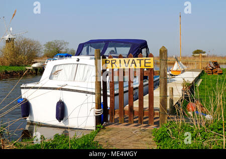 Una piccola diga con attracchi e segno privato dal fiume Thurne su Norfolk Broads a Thurne, Norfolk, Inghilterra, Regno Unito, Europa. Foto Stock