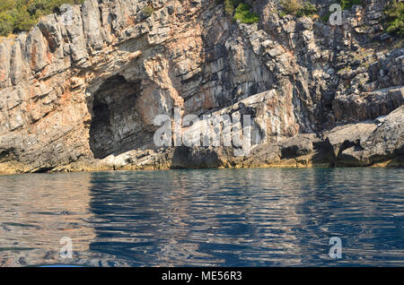 Entrata in una grotta con un mare calmo della superficie dell'acqua Foto Stock