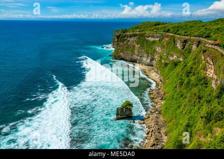 Indonesia. Il clima soleggiato sopra l'oceano e le nuvole all'orizzonte. Un percorso pedonale lungo la parte superiore di una rocciosa costa tropicale. Mandrini per il resto Foto Stock