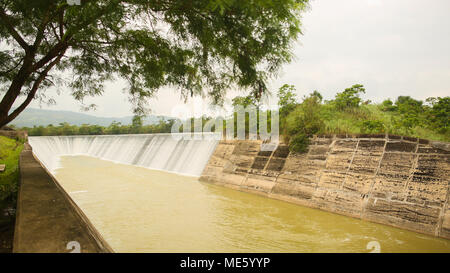 Dettaglio di uno stramazzo annegato weir - il fiume attraverso il cielo con le nuvole la riflessione sulla superficie dell'acqua. Filippine. A Bohol. Foto Stock