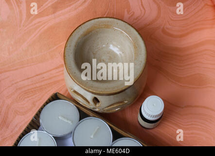 Diffusore in ceramica, bottiglia di olio essenziale naturale e pranzo tè luci su carta a mano Foto Stock