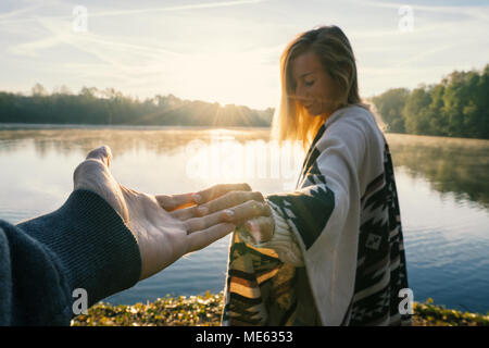 Seguimi al concetto, giovane donna che portano il mio ragazzo per il lungolago di sunrise, tenendo le mani, persone viaggi giovane inizio. Girato in Francia, Europa Foto Stock