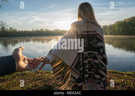 Seguimi al concetto, giovane donna che portano il mio ragazzo per il lungolago di sunrise, tenendo le mani, persone viaggi giovane inizio. Girato in Francia, Europa Foto Stock