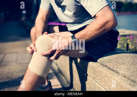 Uomo anziano avente un infortunio al ginocchio Foto Stock