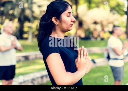 Persona a praticare lo yoga al parco Foto Stock