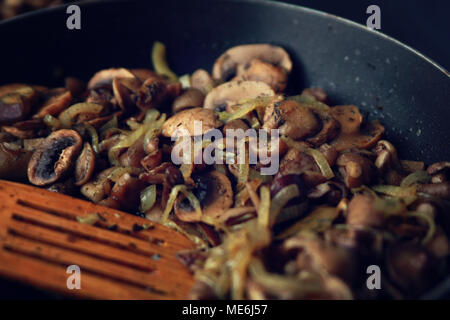 Una padella con un fritto di funghi. Piatto vegano. Funghi Fritti e la cipolla nella padella. Cucina Europea. Panoramica di funghi fritti. Semplice mi vegetariano Foto Stock