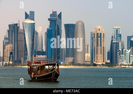 Dhow tradizionale in Vela Corniche promenade. Dietro i grattacieli dello skyline della zona finanziaria di Doha la capitale del Qatar in Arabi Foto Stock