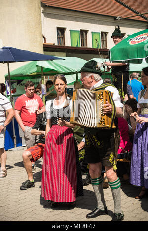 Neuoetting, Germania. Il 21 aprile 2018. Un uomo in tipici abiti bavarese riproduce l'accordeon Foto Stock