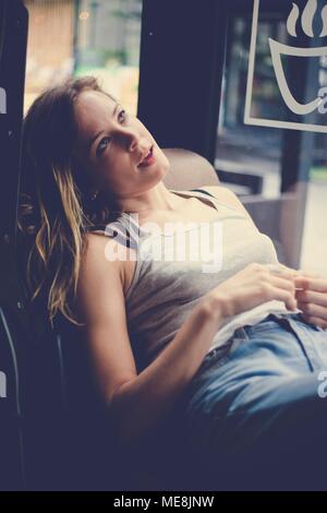 Giovane donna caucasica rilassante in un cafe Foto Stock