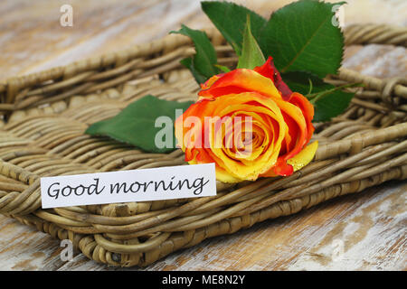 Buona mattina scheda con uno rosso e rosa gialla cosparso con glitter sulla superficie di vimini Foto Stock