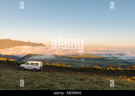 WITSIESHOEK, SUD AFRICA - 13 Marzo 2018: Sunrise sulla strada per la sentinella parcheggio nel Drakensberg con i monti Maluti a sinistra e Foto Stock