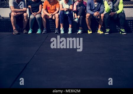 Gruppo di diversi atleti seduti insieme Foto Stock