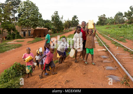 Lugazi, Uganda. 17 maggio 2017. Sorridente bambini ugandesi in esecuzione su un binario ferroviario in una zona rurale in Uganda. Foto Stock