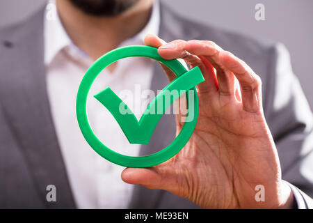 Close-up di un imprenditore di mano azienda Icona segno di spunta verde Foto Stock