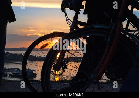 Giovane con una bicicletta sul tramonto a Kaivopuisto park, Helsinki, Finlandia. Foto Stock