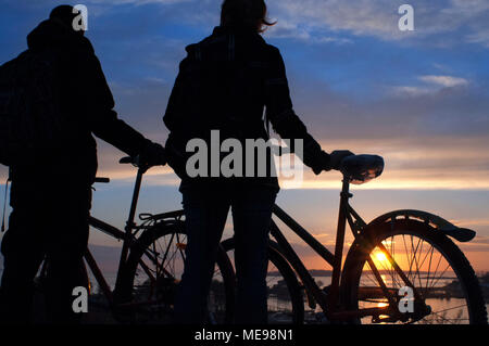 Giovane con una bicicletta sul tramonto a Kaivopuisto park, Helsinki, Finlandia. Foto Stock