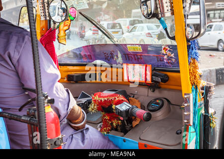 La guida nel traffico indiano: vista dentro la cabina colorate di una tipica indiana di tuk-tuk sulle strade di New Delhi, Punjab, India Foto Stock