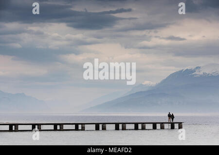 Un paio di prendere in vista da un molo passerella a Sirmione, sul lato sud del Lago di Garda, Italia. Foto Stock