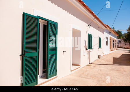 Portoghese imbiancate agriturismo cottage con red tegole di terracotta nelle zone rurali a Algarve, Portogallo. Foto Stock